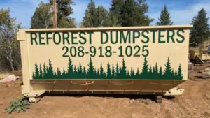 Reforest Dumpsters container set on a dirt lot surrounded by tall pine trees with equipment nearby